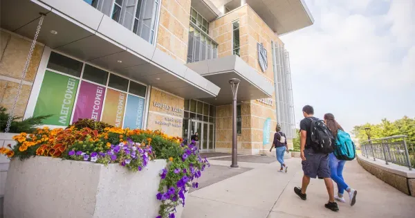 Photo of three students walking into the Gateway entrance of Madison College Truax campus.